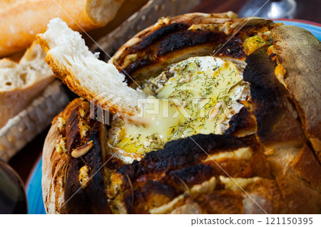 Camembert cheese fondue in bread 121150395