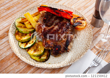 Grilled beef chop dinner served with vegetable garnish 121150412
