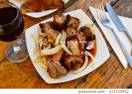 Grilled pork meat shashlik with sliced onion 121150482
