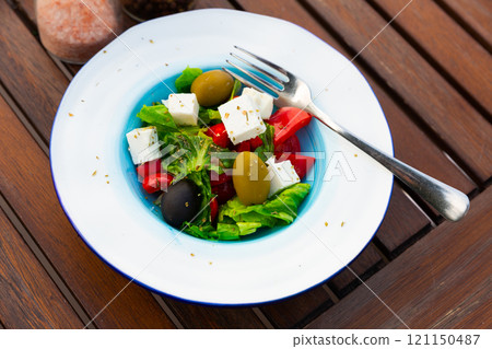 Salad with olives, tomatoes, cucumber and feta cheese - greek vegetable salad. Traditional mediterranean cuisine Salad with olives, tomatoes, cucumber and feta cheese - greek vegetable salad. Traditional mediterranean cuisine 121150487