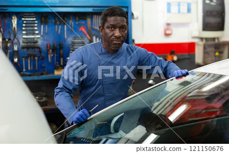 Professional man car mechanician repairing car in auto repair 121150676