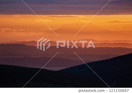 Sunset Hilly Landscape, volcano in the distant background Sunset Hilly Landscape, volcano in the distant background 121150687