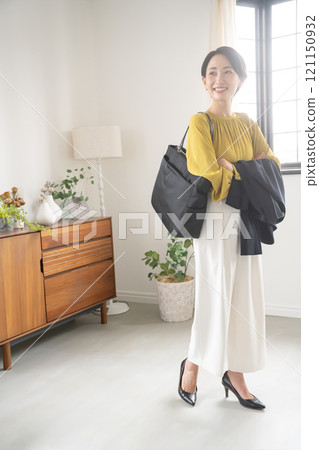 Woman with bag and jacket indoors 121150932