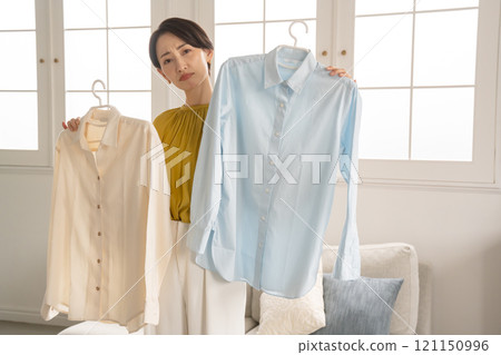 選擇衣裳的婦女在屋子裡 121150996