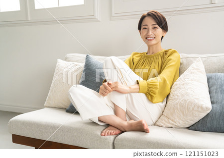 Portrait of a young woman sitting on a sofa Portrait of a young woman sitting on a sofa 121151023