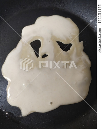 Liquid pancake batter with eyes in a pan 121151135