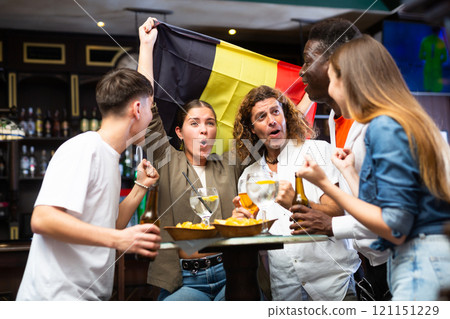Group of football fans cheering for favorite Belgian team in sports bar Group of football fans cheering for favorite Belgian team in sports bar 121151229