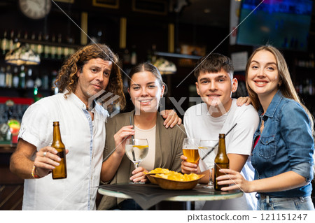 Portrait of happy friends in beer bar chatting and drinking beer Portrait of happy friends in beer bar chatting and drinking beer 121151247