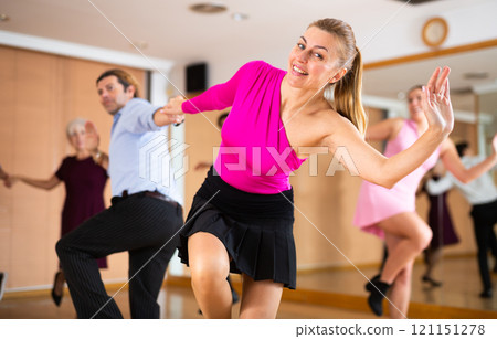 Confident female dancer practicing ballroom dances in ballroom 121151278