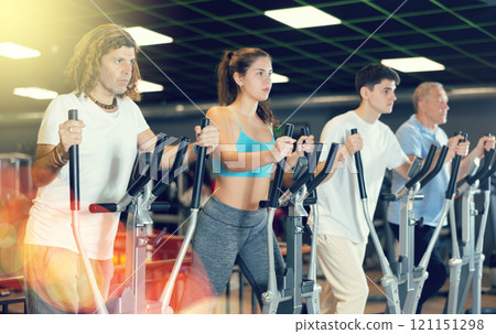 Race walking on elliptical trainers in modern gym 121151298