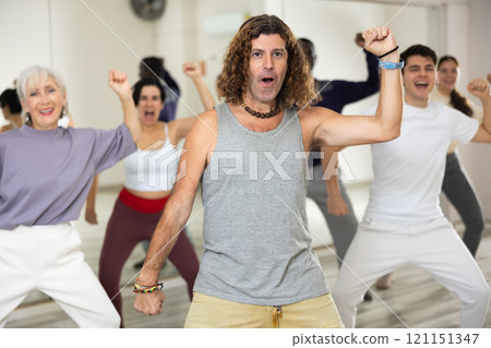 Expressive man learning to dance krump with group in studio Expressive man learning to dance krump with group in studio 121151347