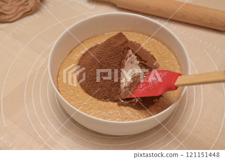 Christmas homemade baking, ingredients for baking gingerbread, silicone spatula in a white bowl with cocoa and flour 121151448