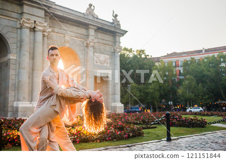 Couple dancing swing in front of Puerta de Alcala in Madrid at sunset 121151844