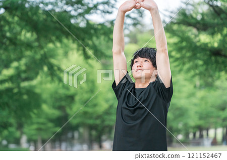 A young man in sportswear taking a deep breath (forest bathing, stress relief, mood change, morning activities, warm-up exercises, sunbathing) 121152467