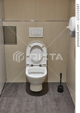 Toilet seat open, tiled restroom 121152887