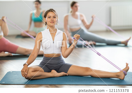 Group of young women doing pilates with loop 121153378