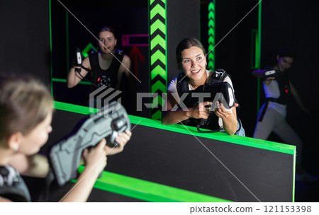 Girls play laser tag, jokingly fight with light weapons Girls play laser tag, jokingly fight with light weapons 121153398