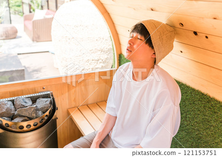 Young Asian man wearing a sauna hat in a sauna 121153751