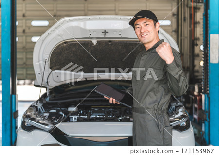 男性汽車機械師使用平板電腦檢查汽車的引擎室 男性汽車機械師使用平板電腦檢查汽車的引擎室 121153967