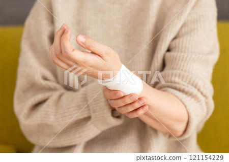 握著纏著繃帶的手腕的中高級婦女 121154229