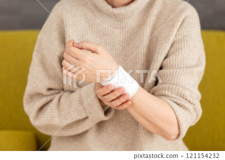 A middle-aged to senior woman holding her bandaged wrist 121154232
