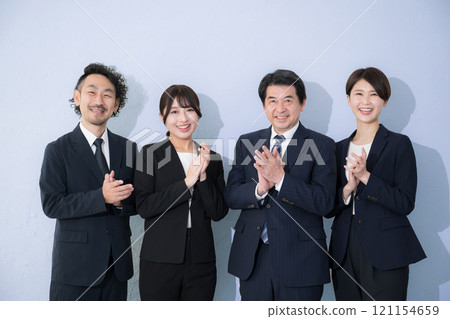 多位身著西裝的成功人士鼓掌歡呼，看著鏡頭，臉上浮現成功的形象，淺藍色背景 121154659