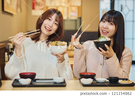 Women eating seafood bowls. Photo courtesy of Peer Bandai. 121154862