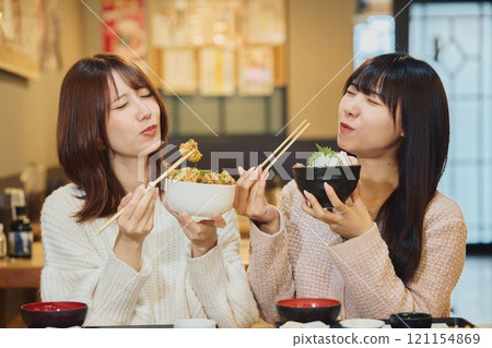 Women eating seafood bowls. Photo courtesy of Peer Bandai. 121154869