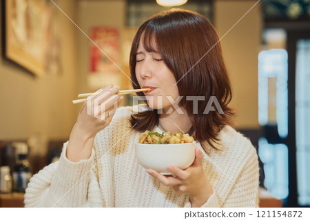A woman eating a seafood bowl with gusto. Photo courtesy of Peer Bandai. 121154872