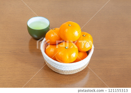 A basket of tangerines and Japanese tea on a kotatsu table 121155313