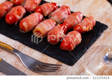 Miniature sausage links wrapped in bacon Miniature sausage links wrapped in bacon 121155419