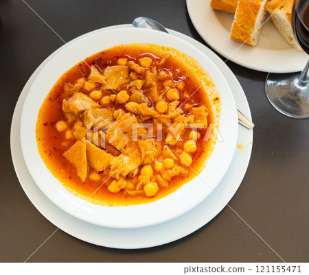 Portion of stewed tripe with chickpea is cooked in plate - stomach of cattle 121155471