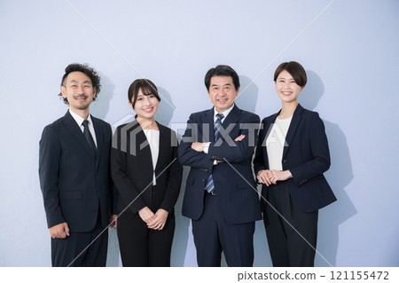 Multiple smiling images in business suits looking at the camera Light blue background Multiple smiling images in business suits looking at the camera Light blue background 121155472