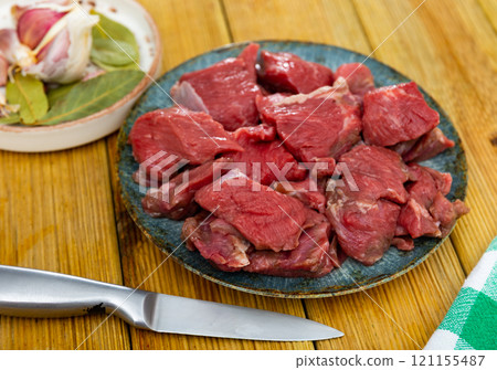 Pieces of raw veal tenderloin and spices, onion, set of products for cooking baked and fried meat Pieces of raw veal tenderloin and spices, onion, set of products for cooking baked and fried meat 121155487