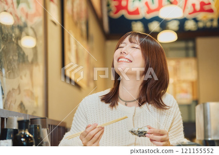 一位女士正在美味地吃牡蠣 攝影由 Pia Bandai 提供。 121155552