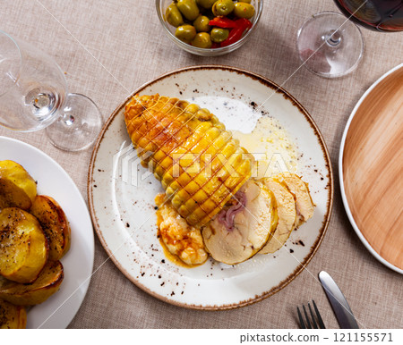 Stuffed chicken served with potatoes on platter 121155571