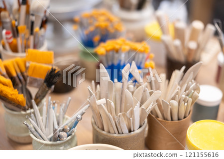 Variety of brushes, wooden spatulas, scrapers used in manual production of ceramic products. 121155616