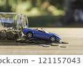 Coins with glass bottle and blue car, business saving and investment concept. 121157043