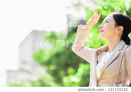 A woman in a suit who is concerned about sunlight 121158182