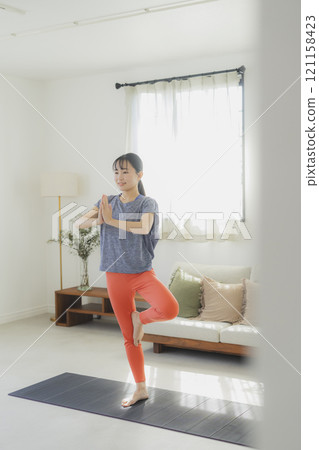 一個女人在客廳做瑜伽 一個女人在客廳做瑜伽 121158423