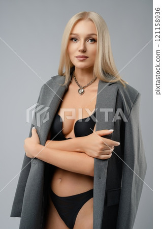A confident young model showcasing an elegant outfit and stylish lingerie 121158936