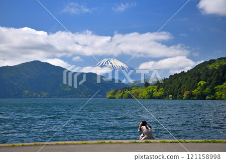 A solo female tourist looking at Mount Fuji and the red torii gates of Hakone Shrine in Hakone Town, Kanagawa Prefecture (1) 121158998