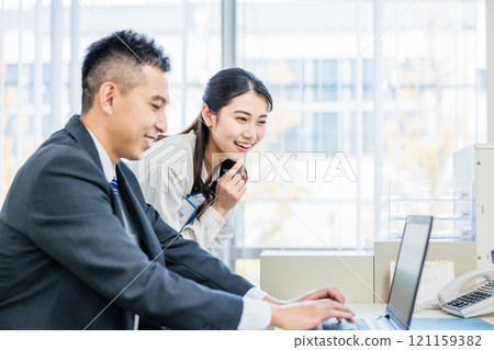 Business person talking with colleague in office 121159382