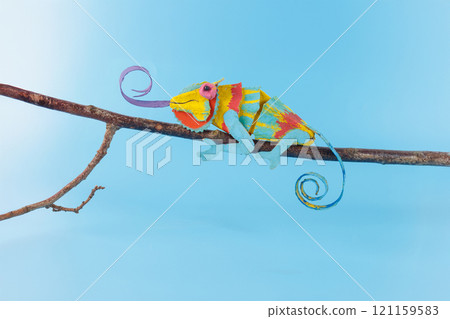 egg box chameleon painted in bright colors perched on a branch egg box chameleon painted in bright colors perched on a branch 121159583