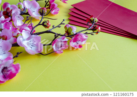 Side view of Chinese New Year decoration and red packets on yellow cover. Chinese New Year celebration concept Side view of Chinese New Year decoration and red packets on yellow cover. Chinese New Year celebration concept 121160175