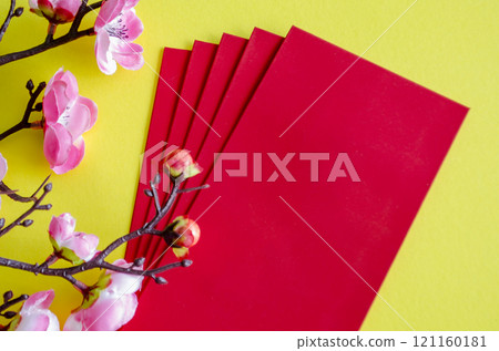 Top view of Chinese New Year with pink flower decoration with red packets on yellow cover background with customizable space for text. Chinese New Year celebration Top view of Chinese New Year with pink flower decoration with red packets on yellow cover background with customizable space for text. Chinese New Year celebration 121160181