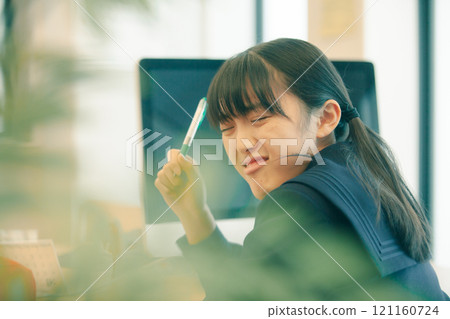 A high school girl is having trouble keeping up with the class and is holding her head A high school girl is having trouble keeping up with the class and is holding her head 121160724