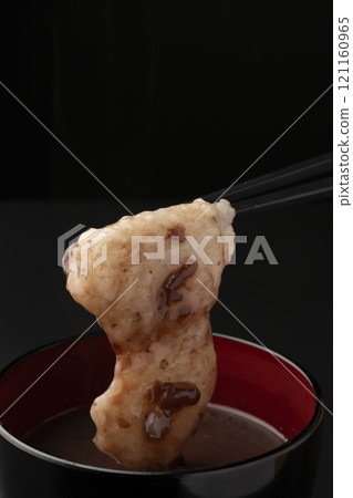 Pick up the mochi in sweet red bean soup with chopsticks Pick up the mochi in sweet red bean soup with chopsticks 121160965