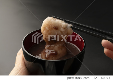 Pick up the mochi in sweet red bean soup with chopsticks Pick up the mochi in sweet red bean soup with chopsticks 121160974