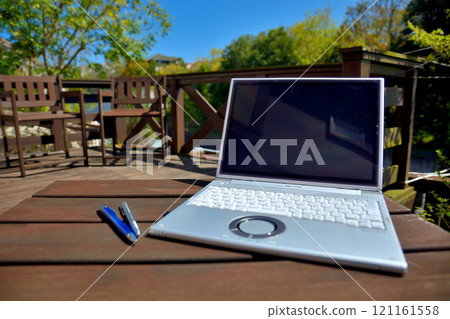 Image of working from home under a blue sky, working or camping on the wooden deck in your backyard (2) 121161558